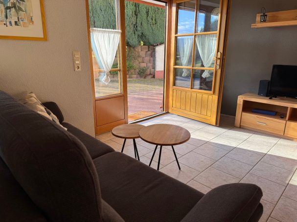 Großes Wohn-/ Esszimmer Gemütliches Wohnzimmer mit Sofa, Couchtisch und Blick auf den Außenbereich.